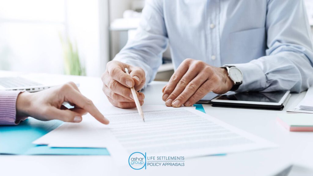 insurance advisor working on life settlement with client signing paperwork